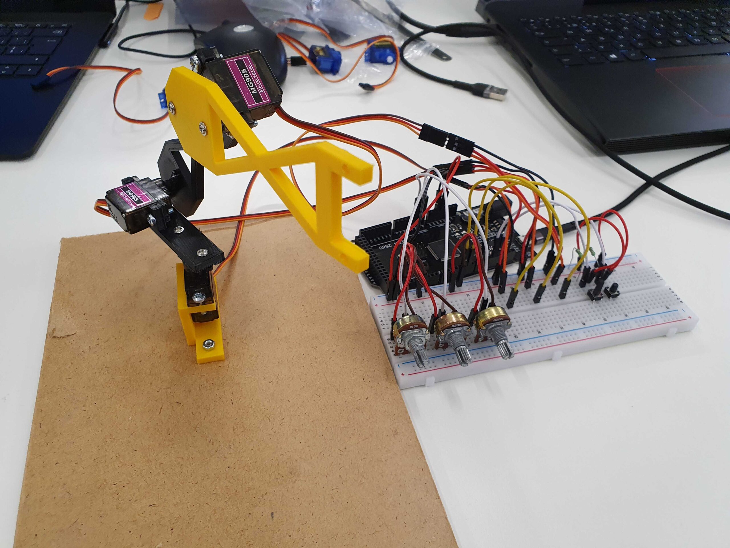 Selbstgebauter Servo-Arm mit Arduino, Steckbrett und Potentiometern – komplexe Mehrkomponenten-Konstruktion.